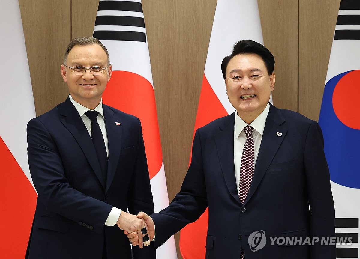 El presidente Yoon Suk Yeol (derecha) y el presidente polaco Andrzej Duda se dan la mano durante una ceremonia cumbre celebrada en la oficina presidencial en Seúl el 24 de octubre de 2024. (Yonhap) 