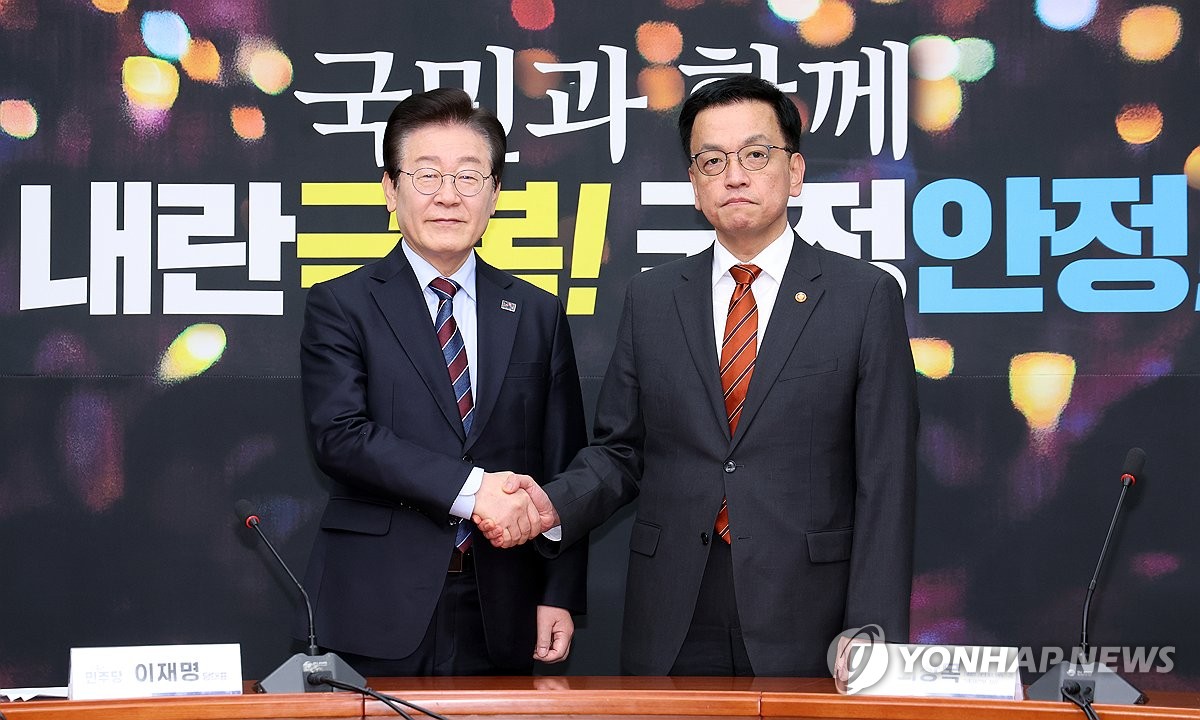 El presidente interino Choi Sang-mok (R), que al mismo tiempo se desempeña como viceprimer ministro de Asuntos Económicos y ministro de Finanzas, posa para una fotografía con Lee Jae-myung, líder del principal partido opositor, el Partido Demócrata, durante su reunión en la Asamblea Nacional en Seúl el 13 de enero de 2025. (Foto de la piscina) (Yonhap)