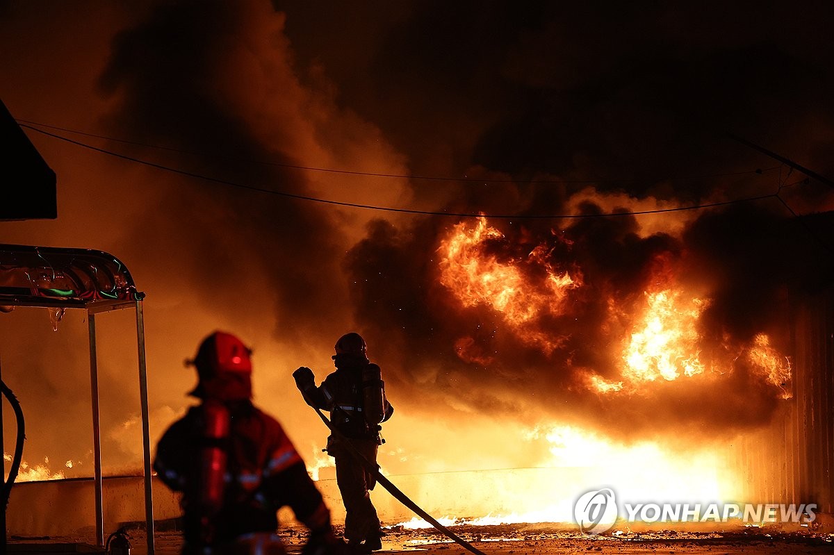 Firefighters extinguish a fire at a factory building that has been engulfed in a wildfire in Uiseong County, North Gyeongsang Province, on March 22, 2025. (Yonhap)