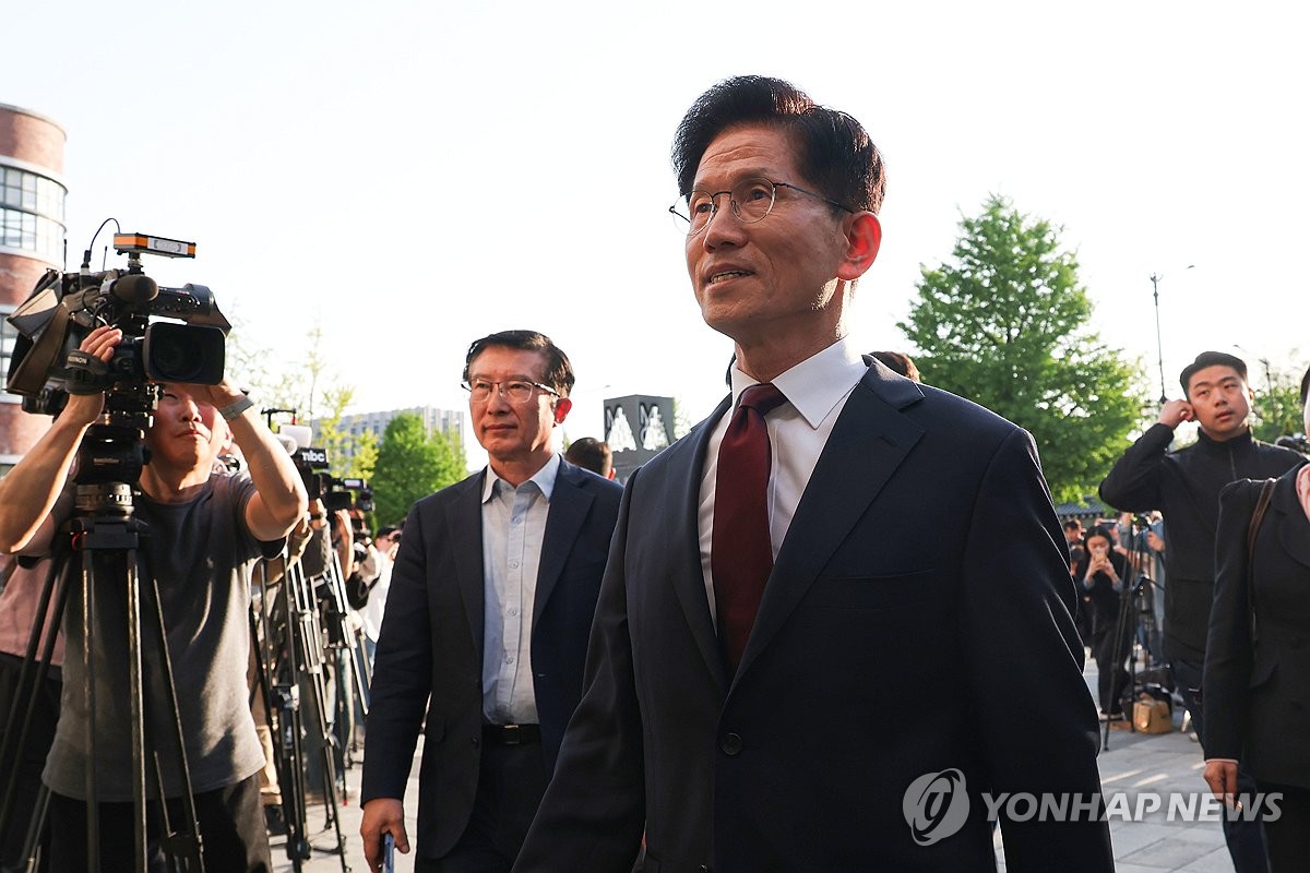 Kim Moon-soo (C), presidential candidate of the People Power Party, walks to a restaurant in Seoul on May 7, 2025, to discuss with former Prime Minister Han Duck-soo, an independent preliminary presidential candidate, a possible unification of their candidacies ahead of the June 3 presidential election. (Pool photo) (Yonhap)